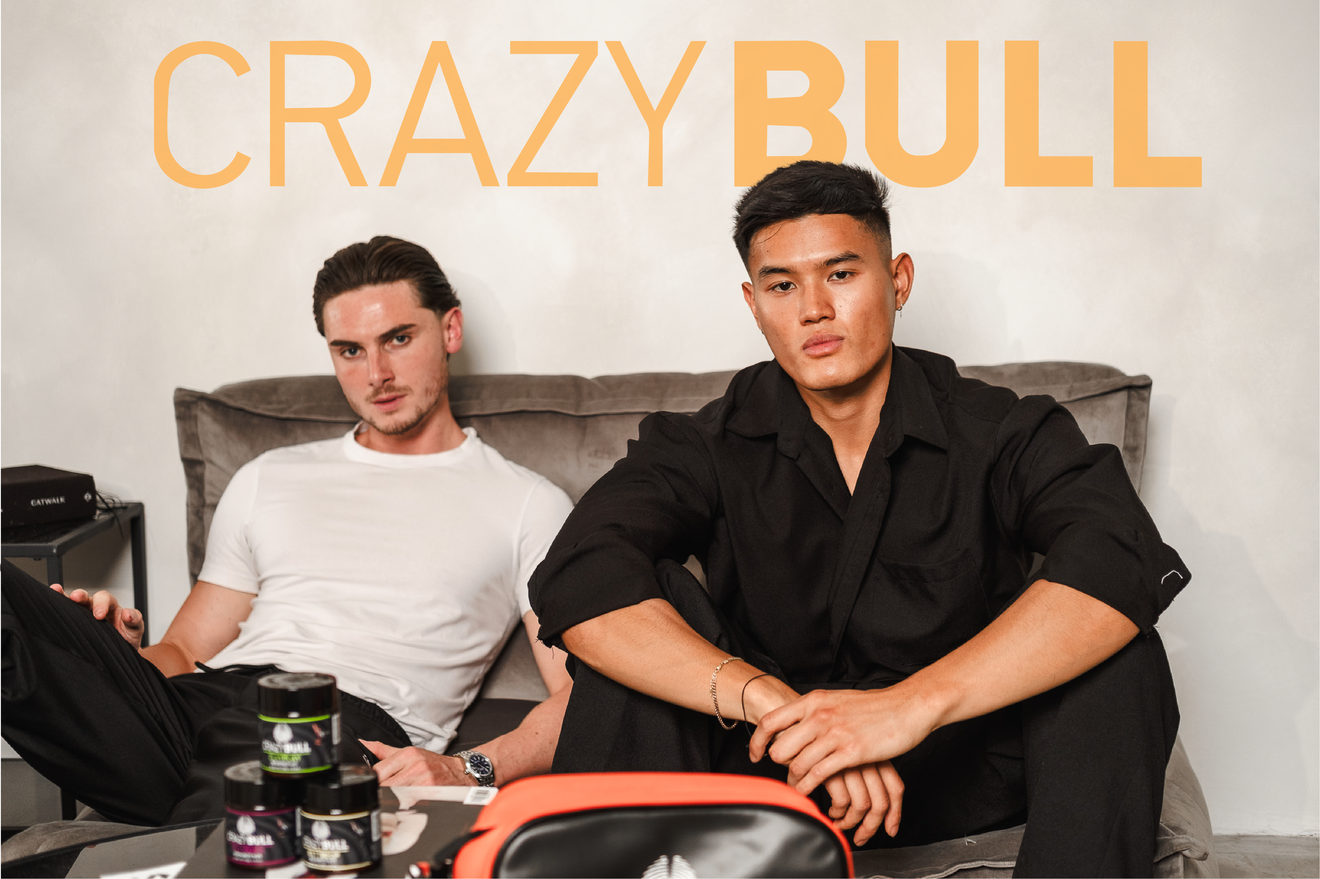 Two men sitting on a couch with 'Crazy Bull' branding in the background