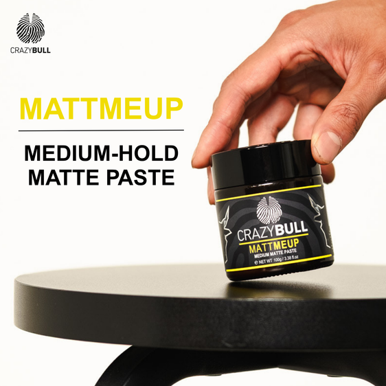 Crazy Bull Mattmeup medium-hold matte paste jar held by a hand on a white background